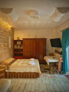 a bedroom with a bed and a desk and a table at Villa 3 papuci in Constanţa