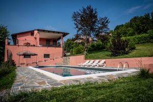 a swimming pool in front of a house at Villa con piscina e intera struttura a uso esclusivo casa del moré in La Morra