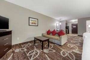 a living room with a couch and a tv at MainStay Suites Lincoln University Area in Lincoln