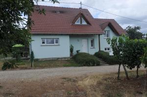 a white house with a red roof at Les cerisiers in Bernardswiller