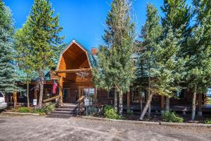 une cabane en rondins avec des arbres devant elle dans l'établissement Bar N Ranch, à West Yellowstone