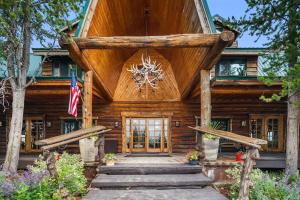 een blokhut met een grote houten voordeur bij Bar N Ranch in West Yellowstone