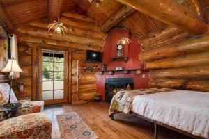 a bedroom in a log cabin with a bed and a fireplace at Bar N Ranch in West Yellowstone