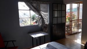 una habitación con una ventana y un banco frente a ella en El laberinto hospedaje en casa en Morelia