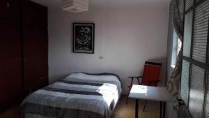 Dormitorio pequeño con cama y mesa en El laberinto hospedaje en casa en Morelia