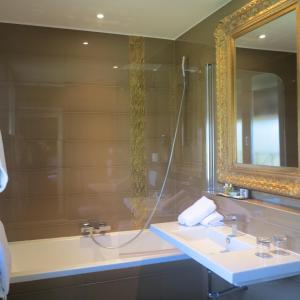 a bathroom with a sink and a mirror and a tub at Hôtel La Villa Cannes in Cannes