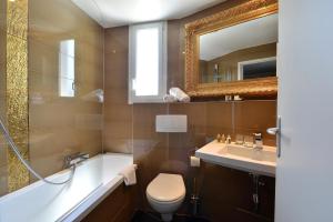 a bathroom with a sink and a toilet and a mirror at Hôtel La Villa Cannes in Cannes