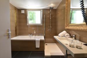 a bathroom with a tub and a sink and a mirror at Hôtel La Villa Cannes in Cannes