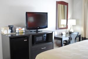 Habitación de hotel con TV en un tocador con cama en Quality Inn & Suites Fresno Northwest en Fresno
