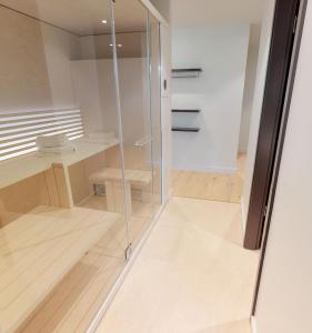 ティメンドルファー・シュトラントにあるWhite Pearl Appartment 0.16のウッドフロアの客室で、ガラス張りのシャワーが備わります。