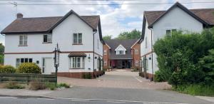 eine Reihe weißer Häuser auf einer Straße in der Unterkunft Stansted Airport Lodge in Takeley