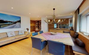 een eetkamer met een tafel en een bank bij Polo in St. Moritz