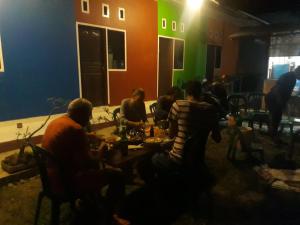 a group of people sitting around a table in a room at Toraja ManuBackPacker in Rantepao +26 photos