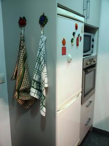 a kitchen with a refrigerator with towels hanging on it at 107 Rosario, Guesthouse in Porto
