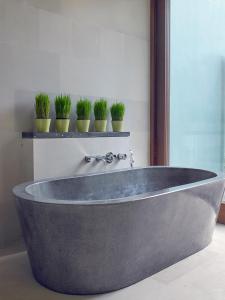 
a bath tub sitting in a bathroom next to a window at The Purist Villas & Spa Ubud in Ubud
