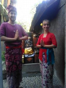 a man and a woman standing next to a building at Utari House in Ubud