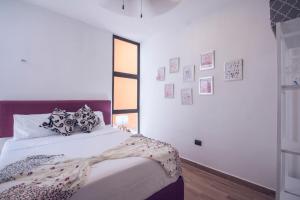 1 dormitorio con 1 cama y una ventana con cuadros en la pared en Hermosos Días Soleados en Villa LUNA DEL MAR, en Telchac Puerto