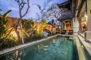 a swimming pool in a villa with a house at Villa Tanah Carik by Mahaputra in Tegalalang
