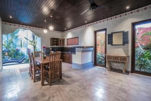 a kitchen with a table and chairs in a room at Villa Tanah Carik by Mahaputra in Tegalalang
