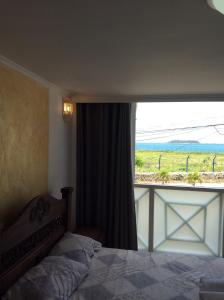 ein Schlafzimmer mit einem Bett und einem großen Fenster in der Unterkunft Casa D Linda II in San Andrés