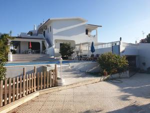 a white house with a fence in front of it at OceanOasis Residences Suites in Olhão