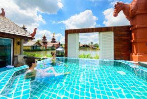 two children swimming in a swimming pool at a resort at Ammata Lanta Resort in Lat Krabang +48 photos