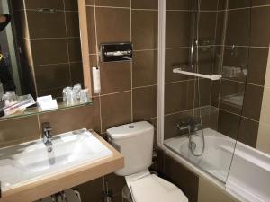 a bathroom with a toilet and a sink and a shower at Best Western Hôtel De France in Chinon
