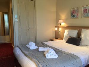 Best Western Hôtel De France في شينون: غرفة في الفندق مع وجود منشفتين على سرير