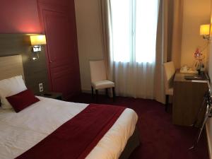 a hotel room with a large bed and a window at Best Western Hôtel De France in Chinon