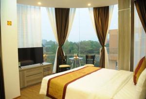 a hotel room with a bed and a large window at Soo Hotel Bac Ninh in Bắc Ninh