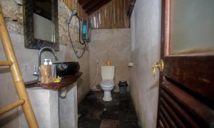La petite salle de bains est pourvue d'un lavabo et de toilettes. dans l'établissement Balangan Sea View Bungalow, à Jimbaran