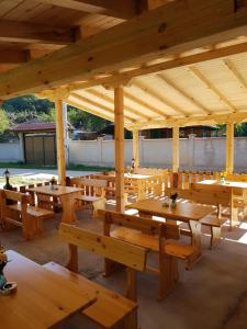 a large wooden pavilion with wooden tables and benches at ЕКО БУНГАЛА in Trŭn +14 photos