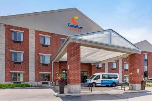 a building with a van parked in front of it at Comfort Suites in Southfield