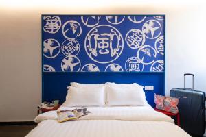 Un dormitorio con una pared azul y blanca y una cama en Kitez Hotel & Bunkz en Kuala Lumpur