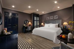 a bedroom with a large white bed and a table at Matilda Boutique Hotel & Spa in Hanoi