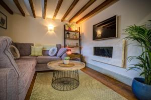 a living room with a couch and a table at Luxury medieval barn in Cotswold town centre in Fairford
