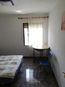 a bedroom with a bed and a table and a window at Nice double room in Alicante in Alicante