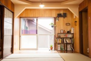 an open door in a room with a book shelf at Guest House tokonoma in Shimo-yuge