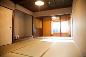 an empty room with a door and a window at Guest House tokonoma in Shimo-yuge