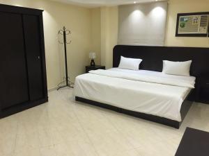 ein Schlafzimmer mit einem großen Bett mit weißer Bettwäsche in der Unterkunft Masfufah furnished Units in Buraida