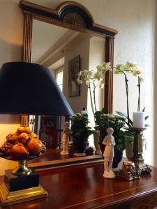 una mesa con una lámpara y un espejo. en Le Grand Appartement, en Sainte-Foy-la-Grande