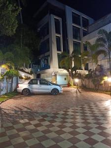 a white car parked in front of a building at OPALO Kailas Kovalam in Kovalam