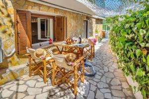 a patio with a table and chairs on a stone patio at Sweet home apartment in Gaios