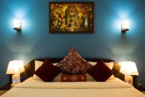 Schlafzimmer mit einem Bett mit Wandgemälde in der Unterkunft Golden Kuensel Resort & Spa in Kalimpong