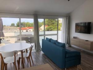 ein Wohnzimmer mit einem blauen Sofa und einem Tisch in der Unterkunft Ideal Holiday Apartment 2 in Tribunj