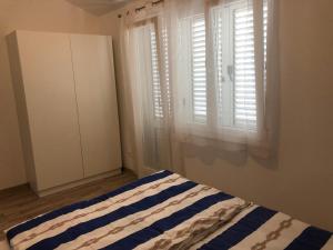 Schlafzimmer mit einem Bett und einem Fenster in der Unterkunft Ideal Holiday Apartment 2 in Tribunj