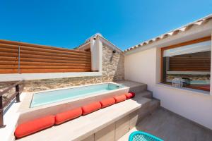 a swimming pool in a house with red seats at Hotel Can Simo in Alcudia