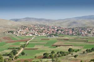a small town in the middle of a green field at Stavroula's Houses in Kélla