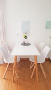 a white table with white chairs and a vase of flowers at Apartment Am Paradies - 10 Minuten Fußweg zur Innenstadt in Limburg an der Lahn