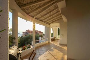 eine Veranda mit Blick auf ein Haus in der Unterkunft Apartments Vicko in Prvić Šepurine